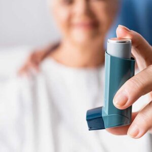 A woman in the hospital with an inhaler